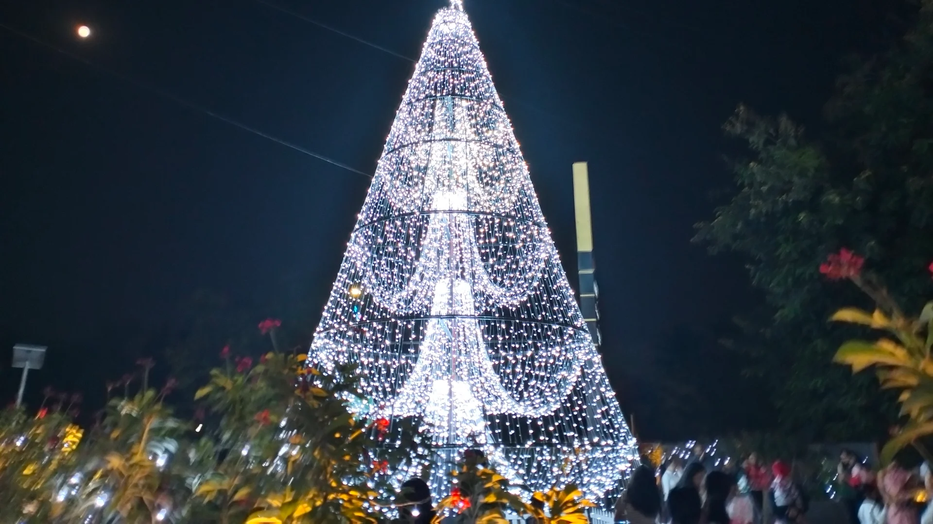 Festive Christmas market with sparkling decorations, market stalls, and colorful lights at night.