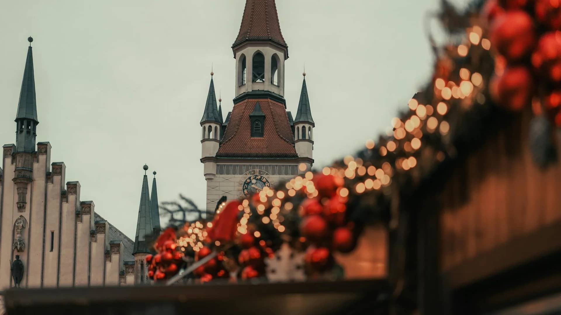 Munich Peterskirche framed by festive red ornaments during winter