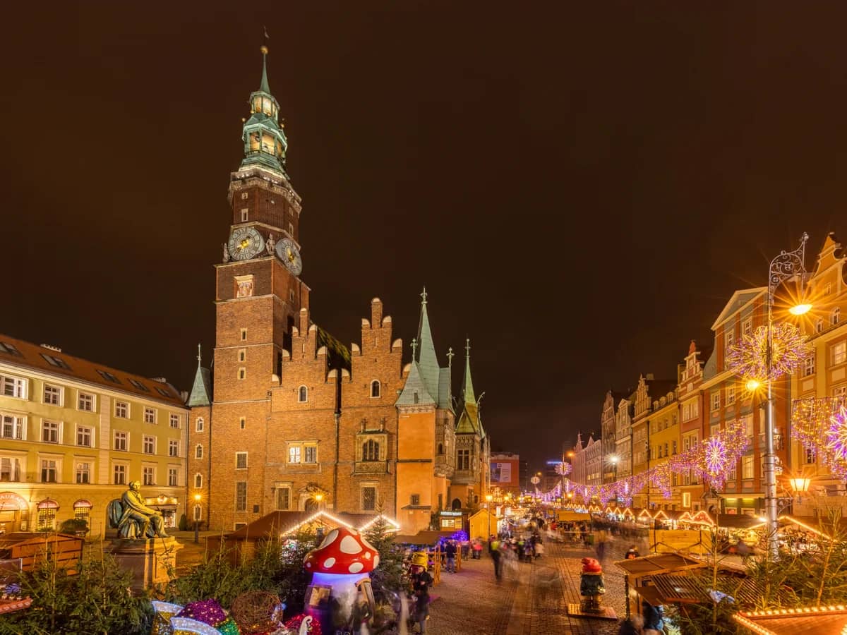 Wroclaw Town Hall illuminated during Christmas season with festive market stalls